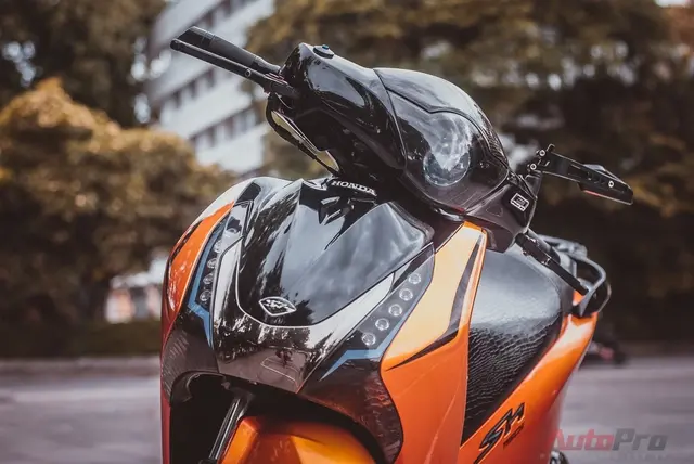 Một người đang chăm sóc chiếc xe SH 2016 màu đỏ