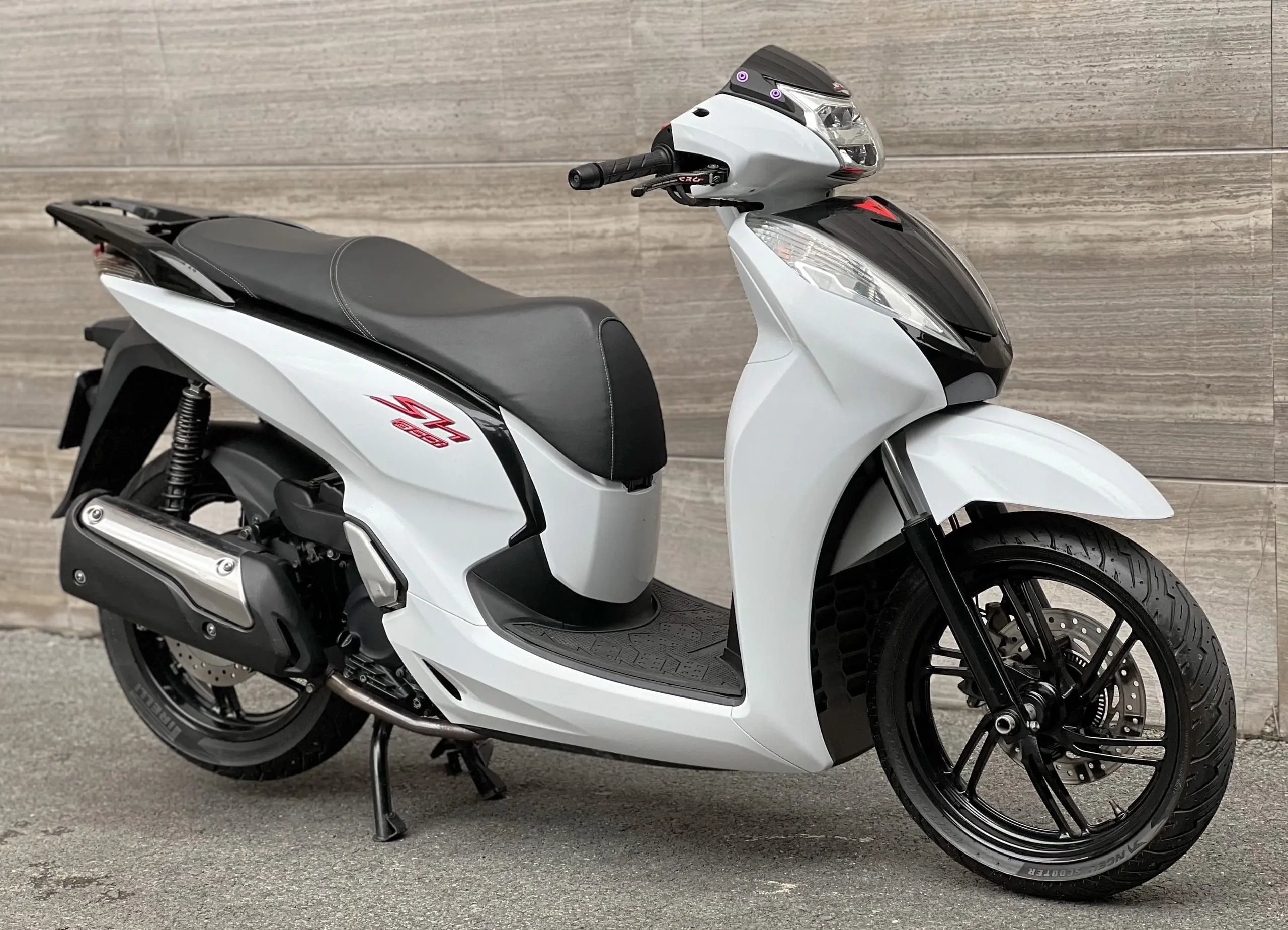 Một người đang chăm sóc chiếc xe SH 2016 màu trắng