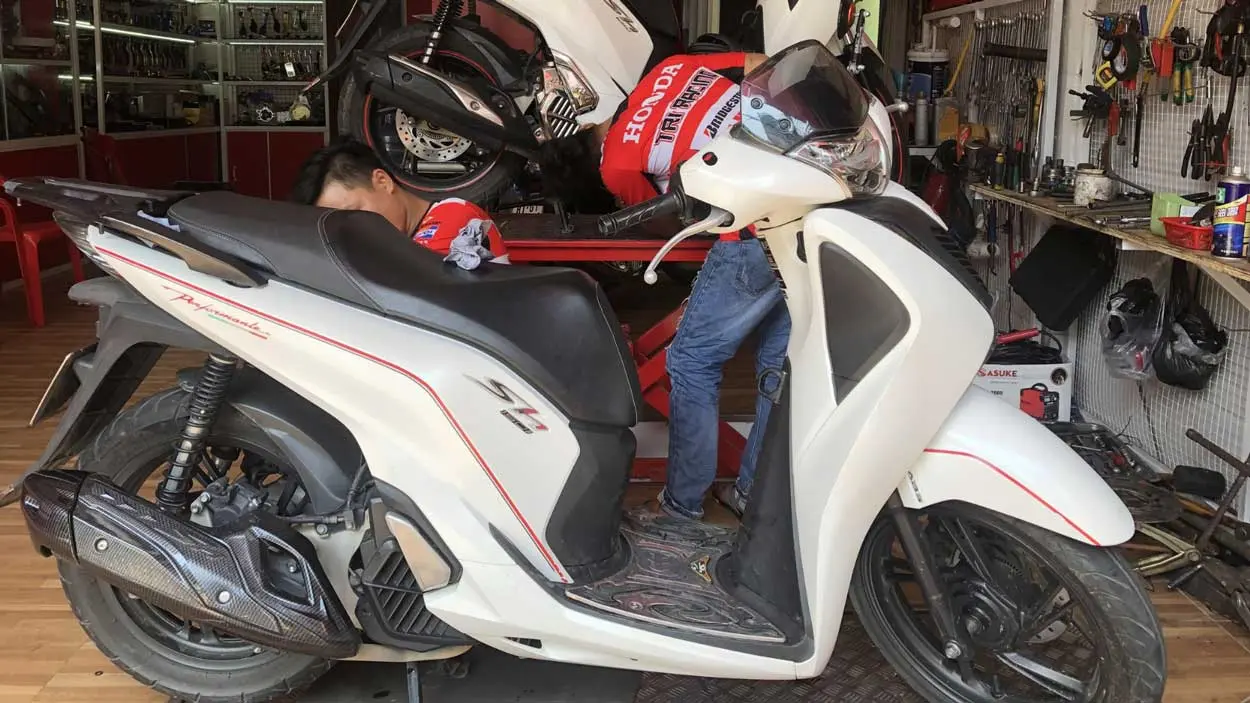 Một người đang chăm sóc chiếc xe SH 2019 màu trắng