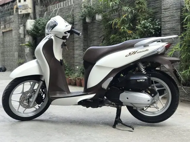 Một người đang cẩn thận lau chùi chiếc xe SH Mode màu trắng