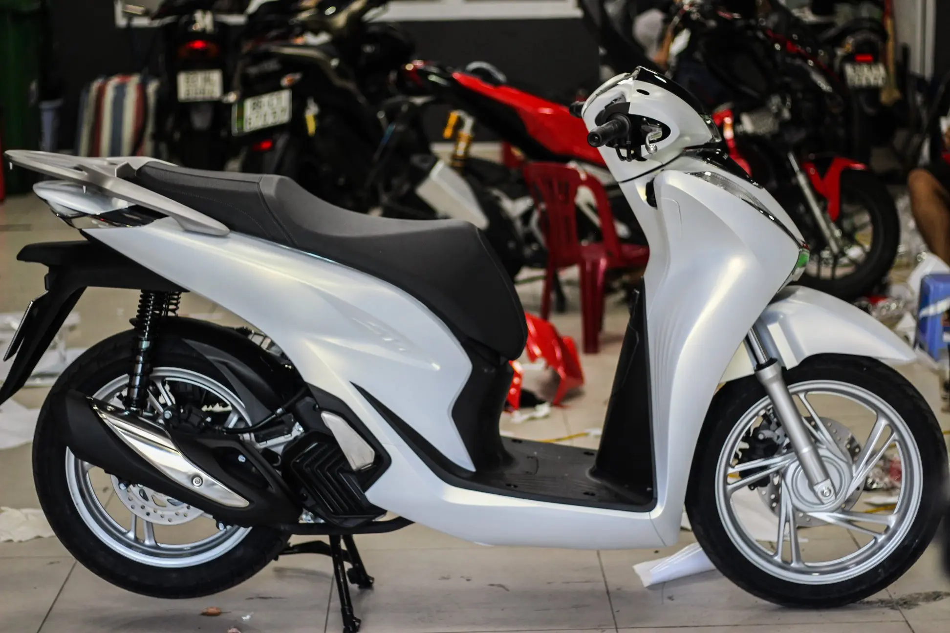 Một người đang cẩn thận lau chùi chiếc xe SH màu trắng