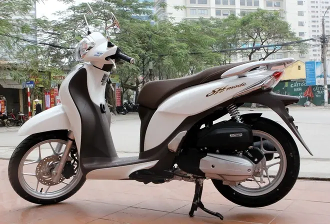 Xe Honda SH Mode màu trắng ngọc trai đang đỗ dưới ánh nắng