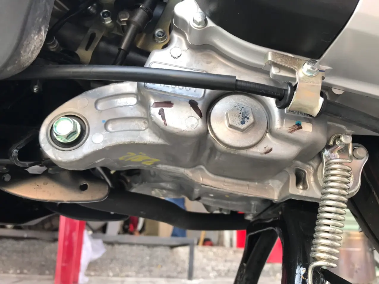 Một người đang kiểm tra chi tiết động cơ của một chiếc xe Air Blade cũ