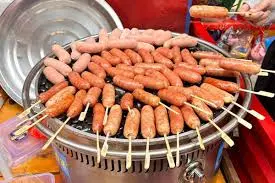 Món lạp xưởng nướng đá đang xèo xèo trên đá cuội nóng